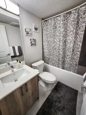 a bathroom with a toilet and a sink and a shower at Calgary Cozy Nest 2BR Suite in Calgary