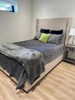 a bedroom with a large bed with a green pillow at Beautiful 2 Bedroom suite in White Rock