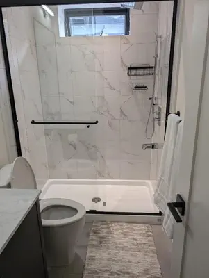 a white bathroom with a toilet and a shower at Beautiful 2 Bedroom suite in White Rock