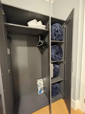a closet with a metal door and some clothes at Cozy home in Vancouver in Vancouver