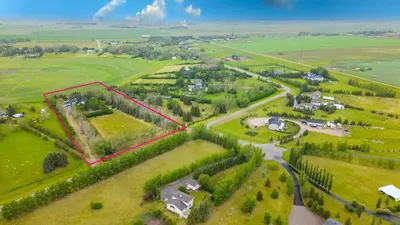 an aerial view of a house in a green field at Walkout Bungalow with Pond Views in Balzac