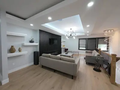 a living room with two couches and a staircase at The Luxe Escape Calgary I 3BR Vacation Home in Calgary
