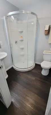 a bathroom with a glass shower and a toilet at Riverside Court RV and Cabins in Grand Forks