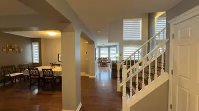 a living room with a staircase and a dining room at The Ridge Escape-3BR Deluxe Stay in Calgary