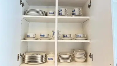 a cupboard filled with plates and bowls and dishes at The Ridge Escape-3BR Deluxe Stay in Calgary