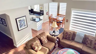 a living room with two couches and a kitchen at The Ridge Escape-3BR Deluxe Stay in Calgary