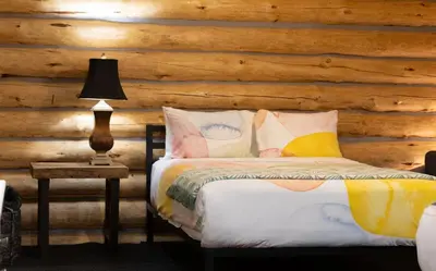 a bedroom with a bed and a wooden wall at River's Edge Glamping in Clearwater