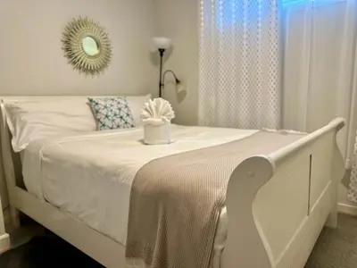 a white bed in a bedroom with a mirror at Global Family Canada in Calgary