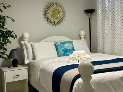 a bedroom with a white bed with a mirror on the wall at Global Family Canada in Calgary