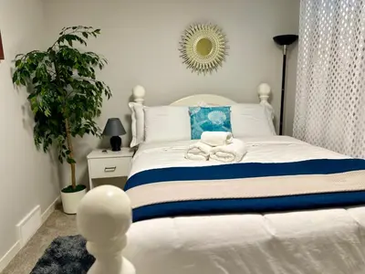 a bedroom with a white bed with towels on it at Global Family Canada in Calgary