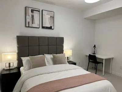 a bedroom with a large bed and a desk at Cozy home away from home in Calgary