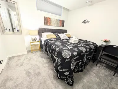 a bedroom with a bed with a black and white comforter at Glacier Ridge 1 bedroom haven in Calgary