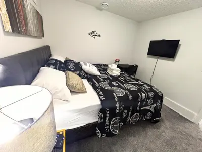 a bedroom with a bed with a black and white comforter at Glacier Ridge 1 bedroom haven in Calgary