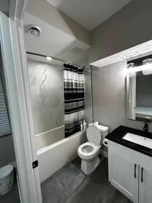 a bathroom with a toilet and a tub and a sink at Entire 2 Ensuite Bedrooms in a Basement in Edmonton