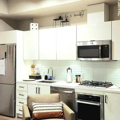 a kitchen with white cabinets and a stove top oven at Luxurious Downtown condo with spectacular views in Calgary