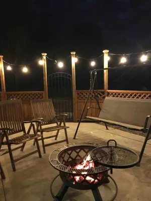 a fire pit on a deck with chairs and lights at Simcoe B&B - Incredible vacation suite in Smithers