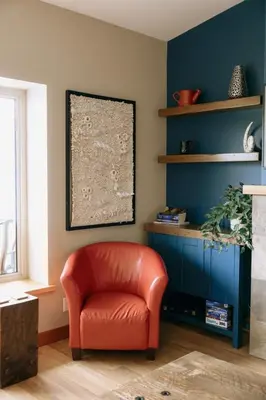 a red chair in a living room with a blue wall at The Moorage - Luxury 2 bed & 2 bath Condo on Marina in Ucluelet