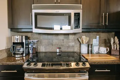 a kitchen with a stove and a microwave at The Moorage - Luxury 2 bed & 2 bath Condo on Marina in Ucluelet