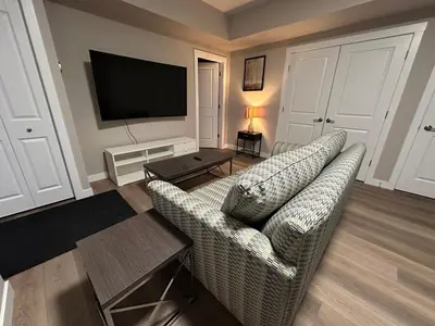 a living room with a couch and a flat screen tv at Cozzy & Brand New Apartment, Near Banff Hwy in Calgary
