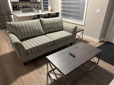 a living room with a couch and a table at Cozzy & Brand New Apartment, Near Banff Hwy in Calgary