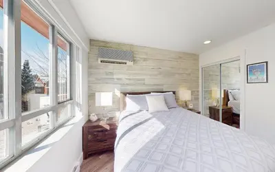 a bedroom with a bed and a large window at Beautiful 1BR in Village Centre in Whistler