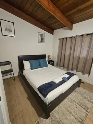 a bedroom with a large bed with blue pillows at P&N Suites - Queen Room- DUBAI in Edmonton