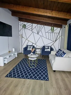 a living room with a couch and a table at P&N Suites - DELUXE QUEEN ROOM- LONDON in Edmonton