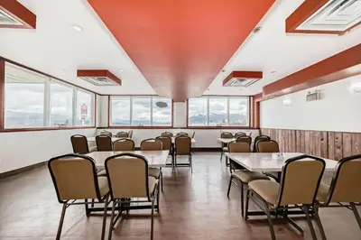 a conference room with tables and chairs and windows at Grande Cache Inn & Suites in Grande Cache