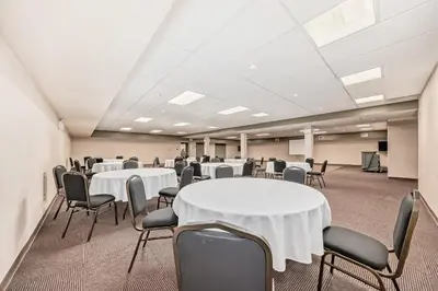 a conference room with white tables and chairs at Grande Cache Inn & Suites in Grande Cache