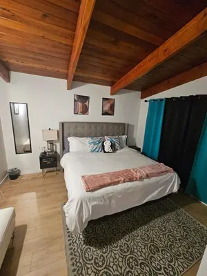 a bedroom with a large bed and wooden ceilings at P&N Suites - DELUXE KING ROOM- PARIS in Edmonton