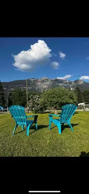 two blue benches sitting in the grass in a field at Luxury Rocky Mountain Glamping in Golden Canada Family Friendly AC Campfire Northern Lights Stargazing in Golden