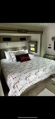 a bedroom with a large bed with a comforter on it at Luxury Rocky Mountain Glamping in Golden Canada Family Friendly AC Campfire Northern Lights Stargazing in Golden