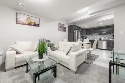 a living room with a white couch and a table at Entire 1 bed and Den Near YEG International Airport in Nisku