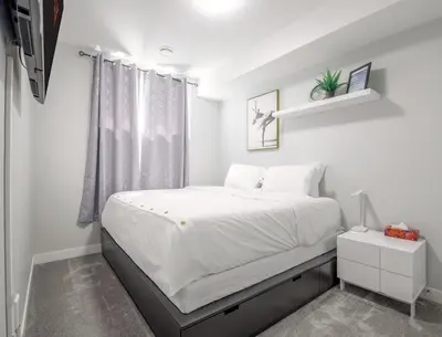 a bedroom with a large white bed with a window at Entire 1 bed and Den Near YEG International Airport in Nisku