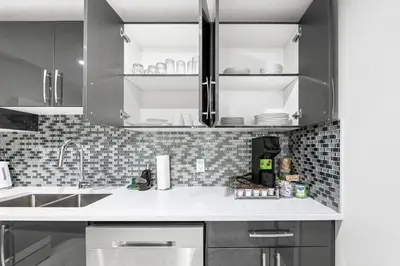 a kitchen with gray cabinets and a white counter top at Entire 1 bed and Den Near YEG International Airport in Nisku