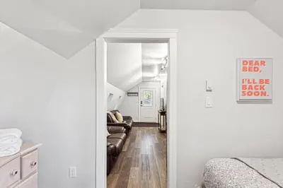 a hallway leading to a bedroom with a bed and a living room at Quiet and rural apartment in the country in Cobble Hill