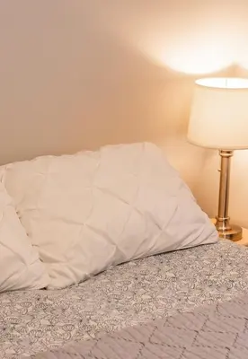 a bed with a white comforter and a lamp at Quiet and rural apartment in the country in Cobble Hill