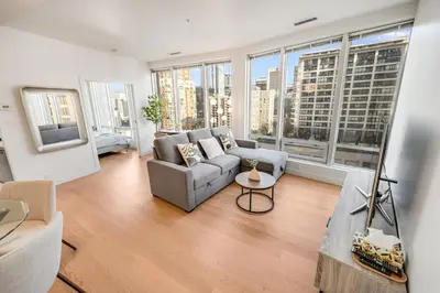 a living room with a couch and large windows at Modern & Cozy Home in the Heart of Downtown Vancouver in Vancouver
