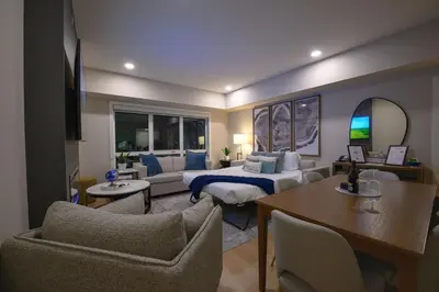 a bedroom with a bed and a living room at 2 bedrooms-3 beds 2 baths-Rocky Creekside Retreat - Top Floor - Heated Pool and Hot Tub in Dead Man's Flats