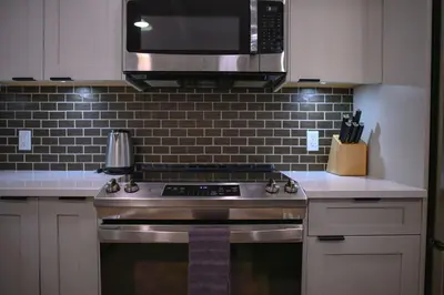 a kitchen with a stainless steel stove and a microwave at 2 bedrooms-3 beds 2 baths-Rocky Creekside Retreat - Top Floor - Heated Pool and Hot Tub in Dead Man's Flats
