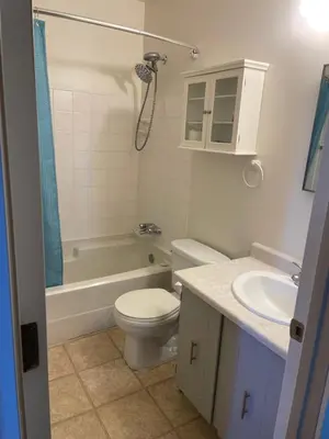 a bathroom with a toilet and a tub and a sink at Cozy & bright private one-bed rm in Edmonton