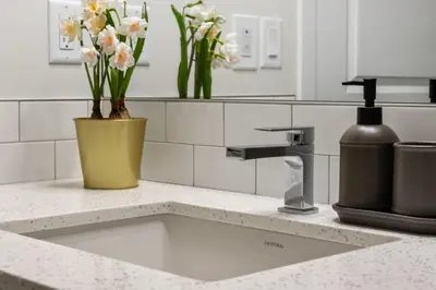 a kitchen counter with a sink with flowers on it at 3 Bedroom Detached Home with Free Parking, Netflix, Free Banff Pass, King Size Bed & Portable AC in Balzac