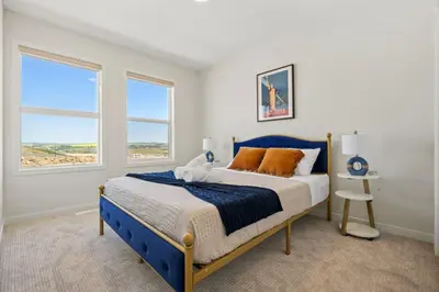 a bedroom with a blue bed and a window at 3 Bedroom Detached Home with Free Parking, Netflix, Free Banff Pass, King Size Bed & Portable AC in Balzac