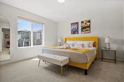 a bedroom with a yellow bed and a window at 3 Bedroom Detached Home with Free Parking, Netflix, Free Banff Pass, King Size Bed & Portable AC in Balzac