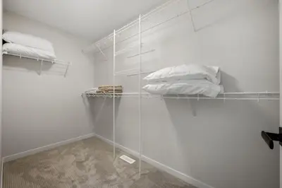 a room with white walls and shelves with pillows at 3 Bedroom Detached Home with Free Parking, Netflix, Free Banff Pass, King Size Bed & Portable AC in Balzac