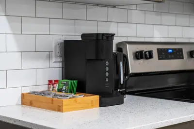 a coffee maker on a counter next to a microwave at Private Lower Suite, Sleeps 4, Queen Bed, Netflix, Parking in Balzac