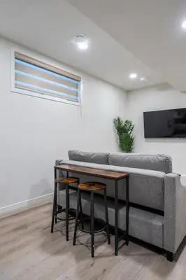 a living room with a couch and a table at Private Lower Suite, Sleeps 4, Queen Bed, Netflix, Parking in Balzac
