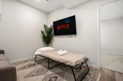 a living room with a tv on a wall at Private Lower Suite, Sleeps 4, Queen Bed, Netflix, Parking in Balzac
