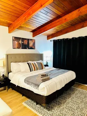 a bedroom with a large bed with black curtains at P and N Suites in Edmonton