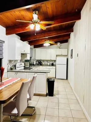 a kitchen with white cabinets and a ceiling fan at P and N Suites in Edmonton